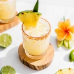 Coconut and pineapple mocktail with lime and toasted coconut rim