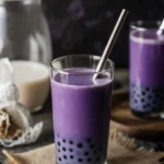 Taro milk tea with boba pearls in a clear glass